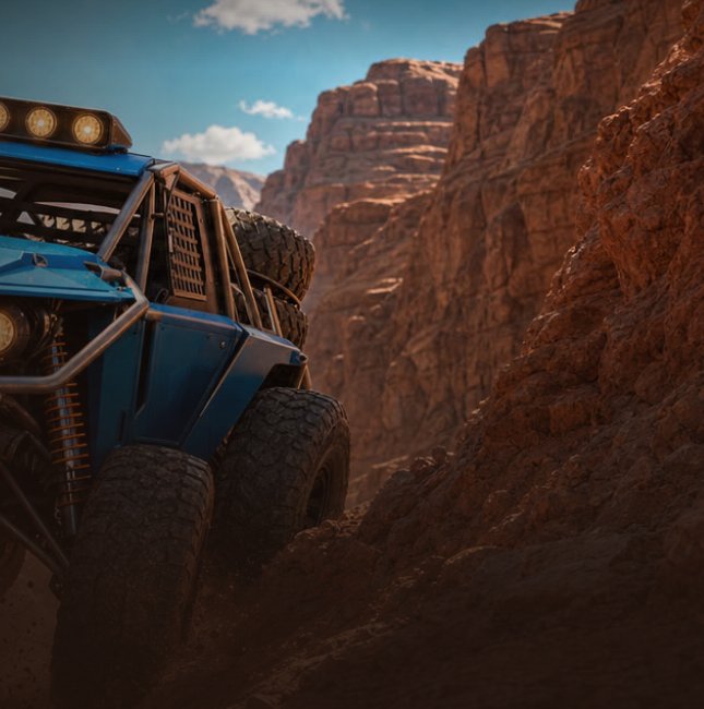 A blue rock crawler climbing through a red sandstone canyon